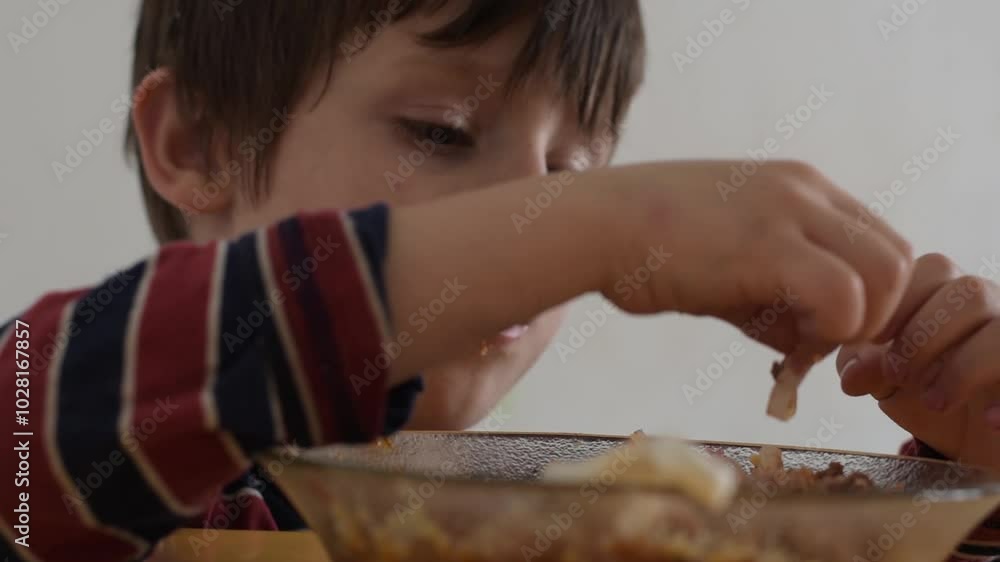 latino child eats pastas by pinching them with fingers latino child eats pastas by pinching them with fingers