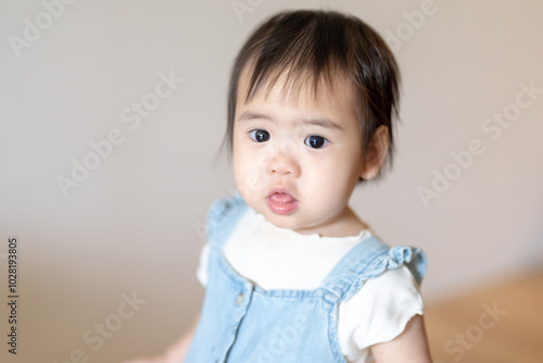 A 1 year old Taiwanese girl spending time playing happily with her parents, a man and woman in their 20s, in a room of a high rise apartment in Taichung City, Taiwan. photo