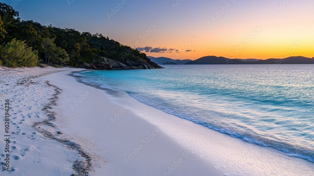 Obraz premium A peaceful beach with soft white sand and crystal-clear turquoise waters, illuminated by the warm hues of a stunning sunrise
