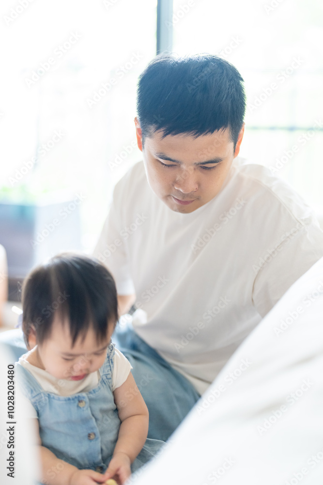 A 1 year old Taiwanese girl spending time playing happily with her parents, a man and woman in their 20s, in a room of a high rise apartment in Taichung City, Taiwan. A 1 year old Taiwanese girl spending time playing happily with her parents, a man and woman in their 20s, in a room of a high rise apartment in Taichung City, Taiwan.