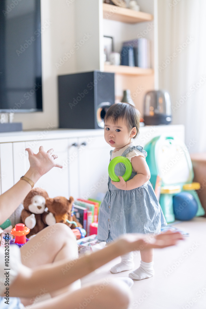 A 1 year old Taiwanese girl spending time playing happily with her parents, a man and woman in their 20s, in a room of a high rise apartment in Taichung City, Taiwan. A 1 year old Taiwanese girl spending time playing happily with her parents, a man and woman in their 20s, in a room of a high rise apartment in Taichung City, Taiwan.