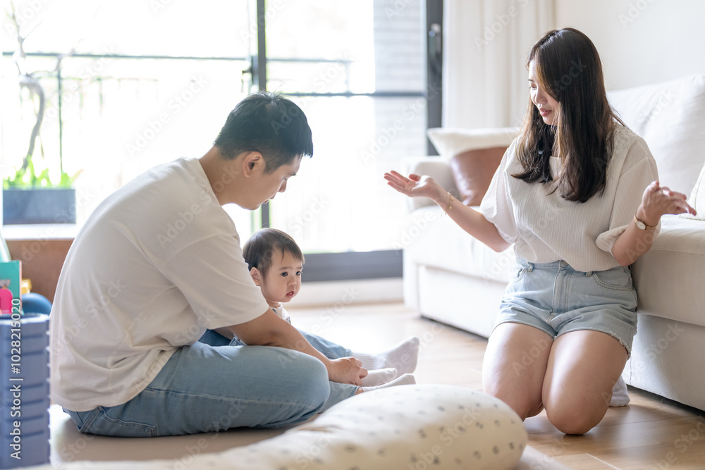 A 1 year old Taiwanese girl spending time playing happily with her parents, a man and woman in their 20s, in a room of a high rise apartment in Taichung City, Taiwan. A 1 year old Taiwanese girl spending time playing happily with her parents, a man and woman in their 20s, in a room of a high rise apartment in Taichung City, Taiwan.