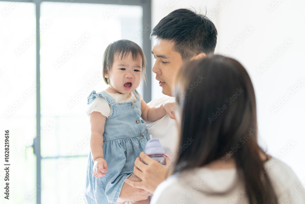 A 1 year old Taiwanese girl spending time playing happily with her parents, a man and woman in their 20s, in a room of a high rise apartment in Taichung City, Taiwan. A 1 year old Taiwanese girl spending time playing happily with her parents, a man and woman in their 20s, in a room of a high rise apartment in Taichung City, Taiwan.
