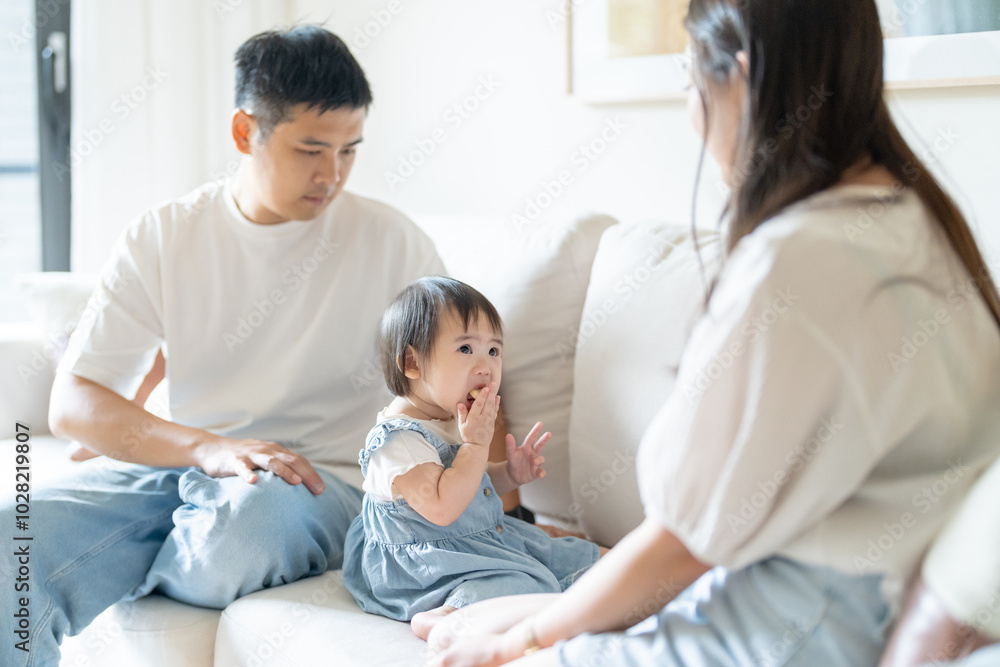 A 1 year old Taiwanese girl spending time playing happily with her parents, a man and woman in their 20s, in a room of a high rise apartment in Taichung City, Taiwan. A 1 year old Taiwanese girl spending time playing happily with her parents, a man and woman in their 20s, in a room of a high rise apartment in Taichung City, Taiwan.
