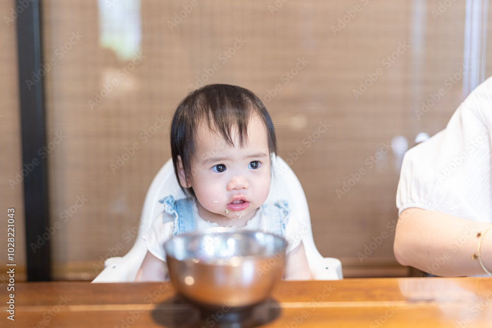 A 1 year old Taiwanese girl enjoying a meal with her parents, a man and woman in their 20s, at a famous Chinese restaurant in Taichung City, Taiwan. A 1 year old Taiwanese girl enjoying a meal with her parents, a man and woman in their 20s, at a famous Chinese restaurant in Taichung City, Taiwan.
