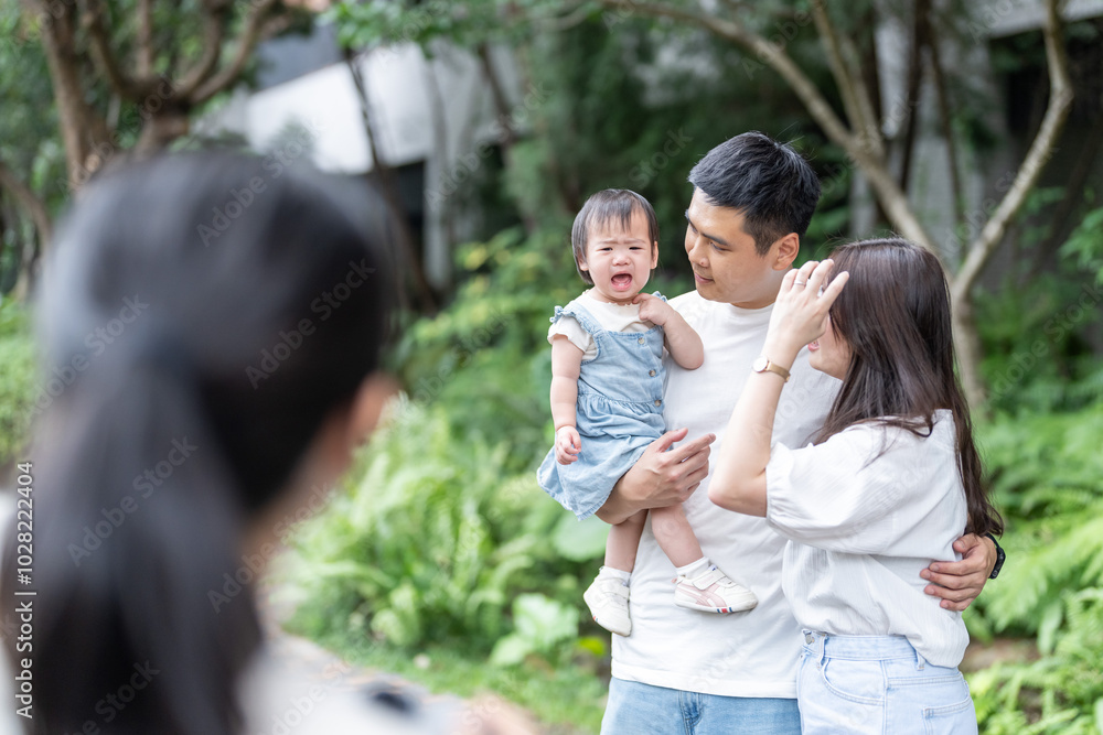 A 1 year old Taiwanese girl spending time with her parents, a man and woman in their 20s, along a roadside in Taichung City, Taiwan, being photographed by a female photographer. A 1 year old Taiwanese girl spending time with her parents, a man and woman in their 20s, along a roadside in Taichung City, Taiwan, being photographed by a female photographer.