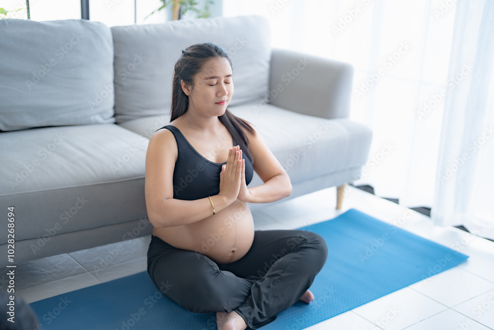 Pregnant asian woman meditation on yoga mat at home relaxation and Self-care during Pregnancy mother mindfulness Positive life moment in pregnancy time Pregnant asian woman meditation on yoga mat at home relaxation and Self-care during Pregnancy mother mindfulness Positive life moment in pregnancy time