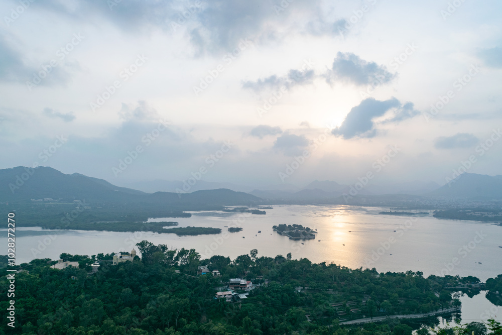 The last rays of the sun are reflecting on lake pichola, surrounded by hills and palaces in udaipur The last rays of the sun are reflecting on lake pichola, surrounded by hills and palaces in udaipur