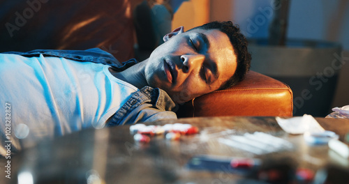 Obraz na plátne Drugs, overdose and man on couch with pills, health risk and narcotic danger in apartment at night