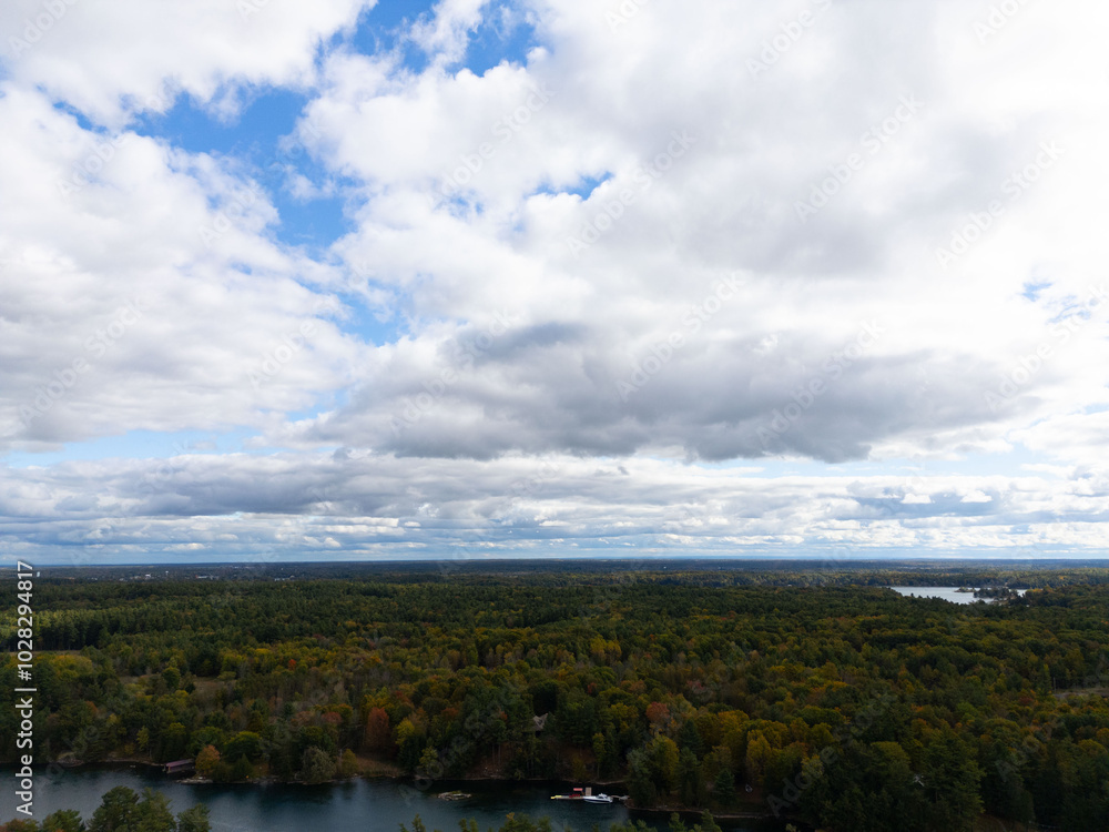 Tranquil aerial view of the 1000 Islands region, showcasing scattered islands on serene waters under a vast sky, capturing natural beauty and peacefulness. Tranquil aerial view of the 1000 Islands region, showcasing scattered islands on serene waters under a vast sky, capturing natural beauty and peacefulness.