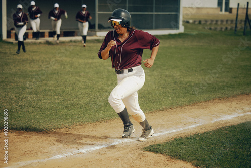 Baseball player aggressively running on base path aiming for home run during intense game photo