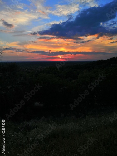 on the horizon there is a soft pink, large and beautiful sunset with rays from the sun and clouds