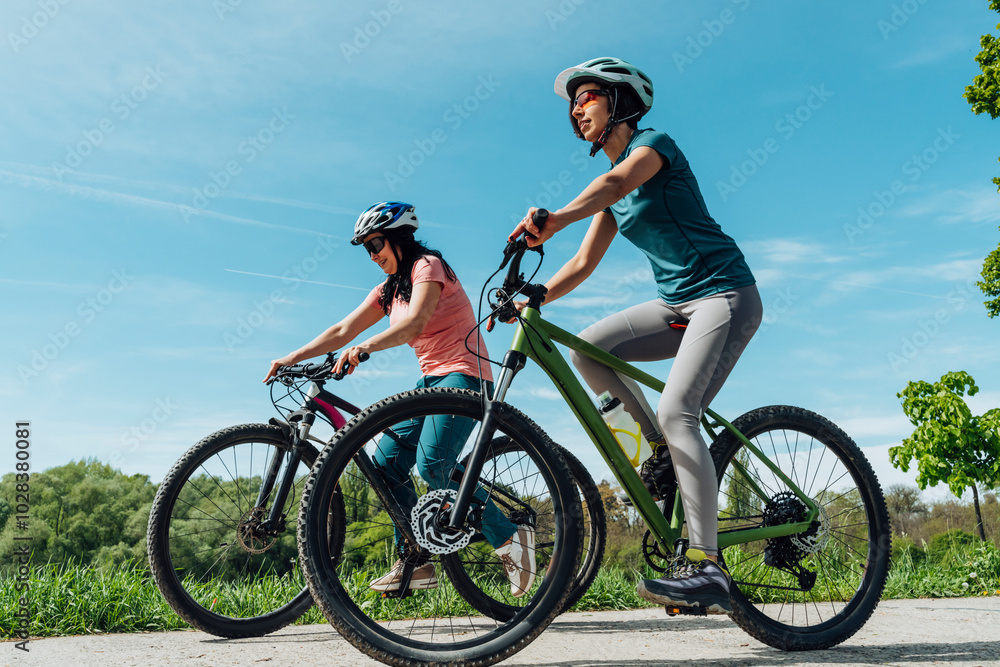 Friends riding bicycle on road under blue sky Friends riding bicycle on road under blue sky