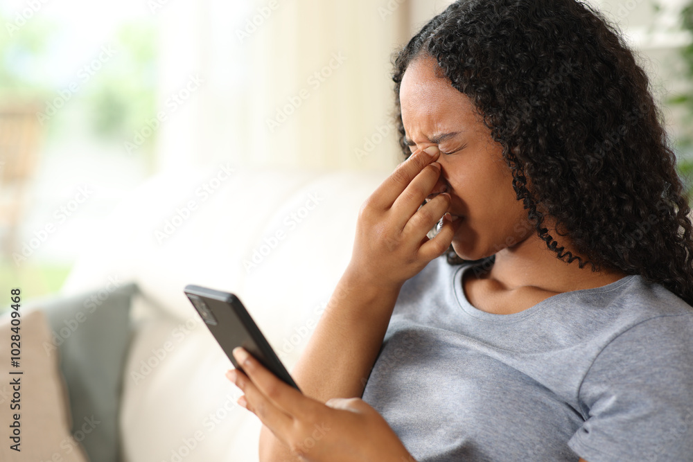 Black woman suffering eyestrain using phone at home Black woman suffering eyestrain using phone at home