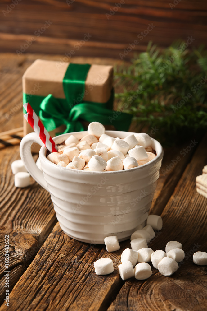 Cup of hot cocoa with marshmallows and gift box on wooden background Cup of hot cocoa with marshmallows and gift box on wooden background