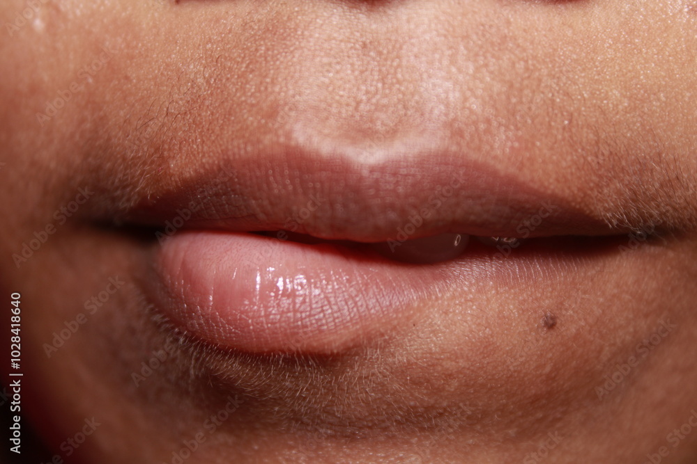 Obraz premium Teeth bitting lips a macro shot of Indian teenage girl mouth