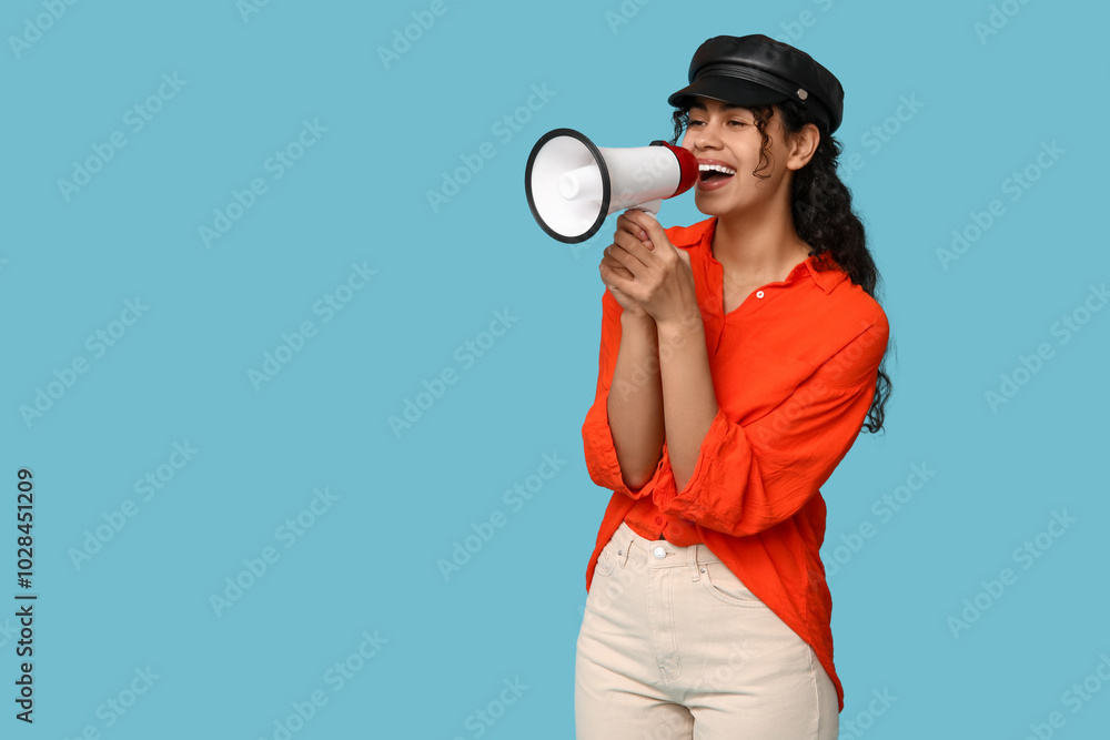 Young African-American woman with megaphone on blue background Young African-American woman with megaphone on blue background