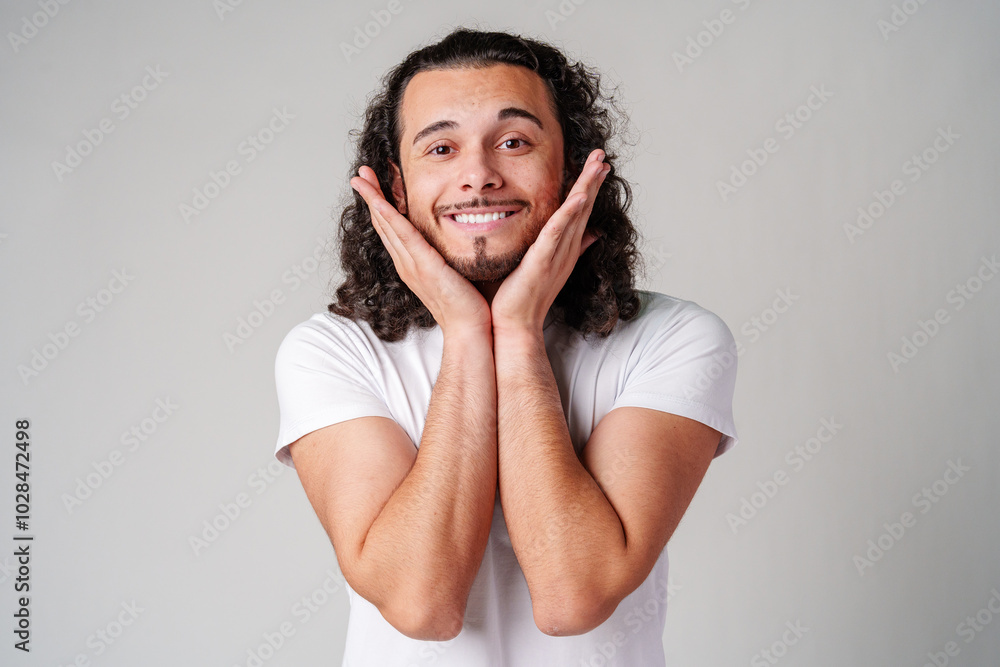 A young man stands thoughtfully against a plain background, expressing contemplation A young man stands thoughtfully against a plain background, expressing contemplation