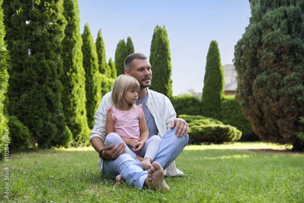 Fototapeta premium Father and his daughter spending time together on green lawn in park
