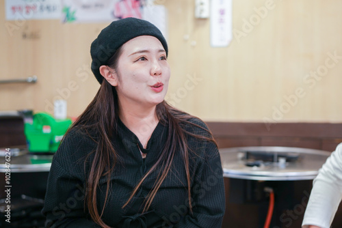 A Korean man and a Japanese woman, both in their 30s and a married couple, are enjoying a meal of Samgyeopsal at a famous restaurant in Jung District, Seoul, Korea, on an autumn night in October.