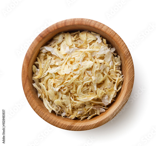 Dried onions in a wooden plate close-up on a white. Top view