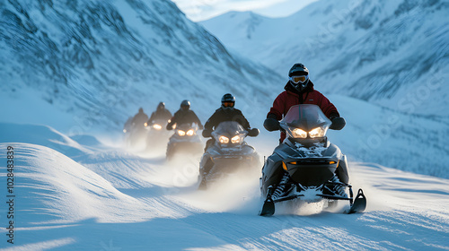 A snowmobile convoy traversing a snow-covered mountain pass with the lead rider signaling the group to follow. photo