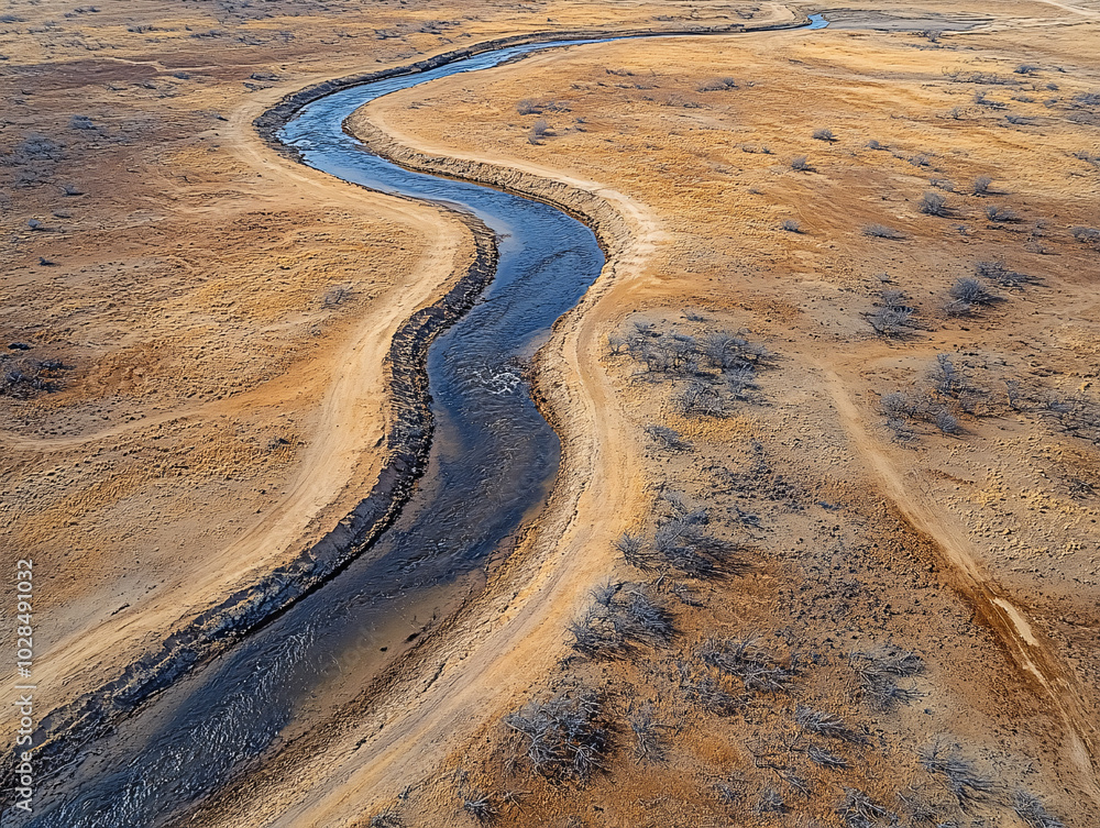 Fototapeta premium aerial shot photograph of a dry_desert of a muddy riverbed with water flowing through it.