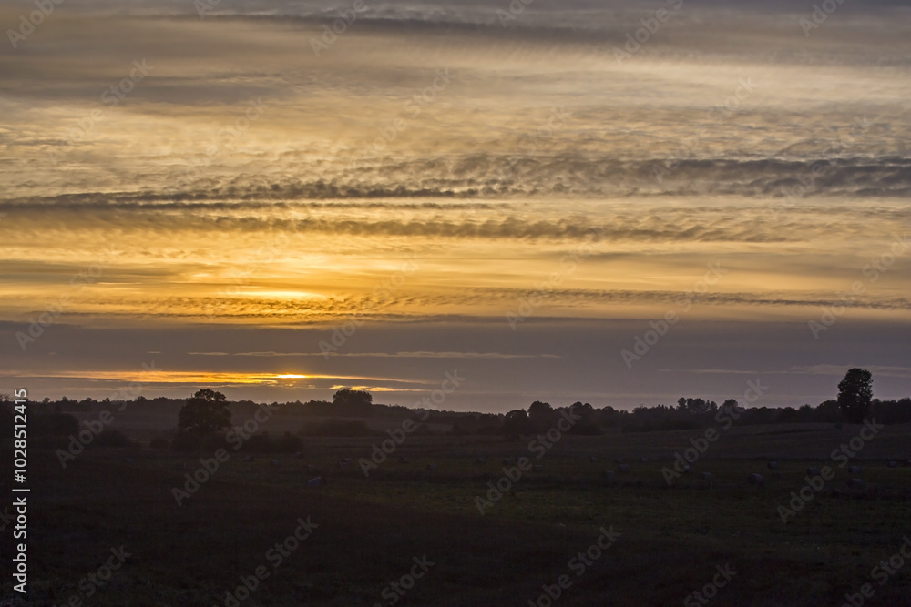 Obraz premium Dramatic sunset over fields and forests. Landscape of eastern Lithuania.