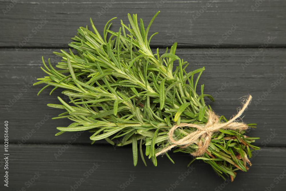 Fresh rosemary bunch on black wooden background Fresh rosemary bunch on black wooden background