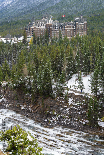 Fairmont Banff Springs and Bow River Falls in snowy autumn sunny day. View from Surprise Corner Viewpoint. Banff National Park, Canadian Rockies. photo