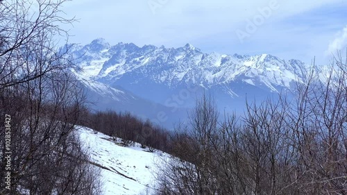 Archonsky Pass. The pass connects the Kurtatinsky gorge with the Alagirsky. Alanya, view of the mountains of the North Caucasus, peaks covered with snow. Sunny day, blue sky with a slight haze. 4К photo