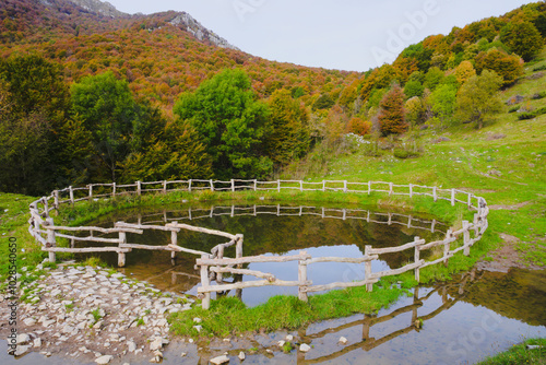 Watering hole with fence, in the Italian mountains. Morterone, Lombardy, Italy photo