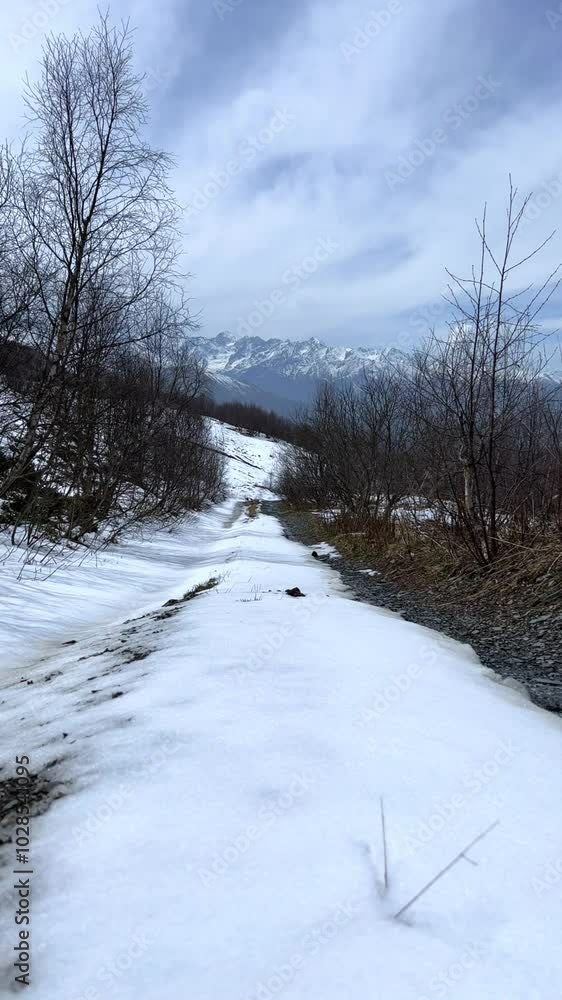 Archonsky Pass. The pass connects the Kurtatinsky gorge with the Alagirsky. Alanya, view of the mountains of the North Caucasus, peaks covered with snow. Sunny day, blue sky with a slight haze. 4К Archonsky Pass. The pass connects the Kurtatinsky gorge with the Alagirsky. Alanya, view of the mountains of the North Caucasus, peaks covered with snow. Sunny day, blue sky with a slight haze. 4К