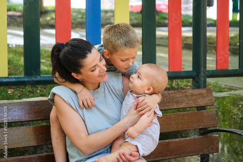 Tender moment with mom embracing her two young children