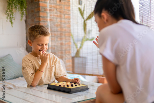 Mother playing board game with her young son photo