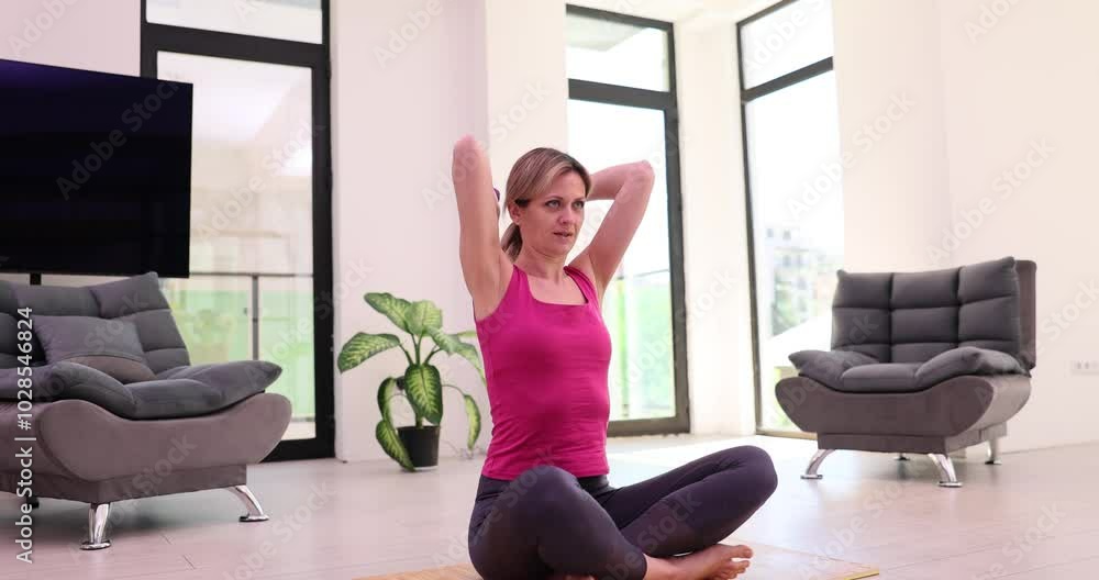 Woman losing weight and exercising with dumbbells sitting at home on yoga mat in morning. Healthy lifestyle and training Woman losing weight and exercising with dumbbells sitting at home on yoga mat in morning. Healthy lifestyle and training