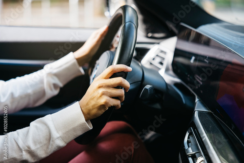 Close-up of a person's hands holding the steering wheel of an electric car, showcasing modern technology and eco-friendly automotive design. photo