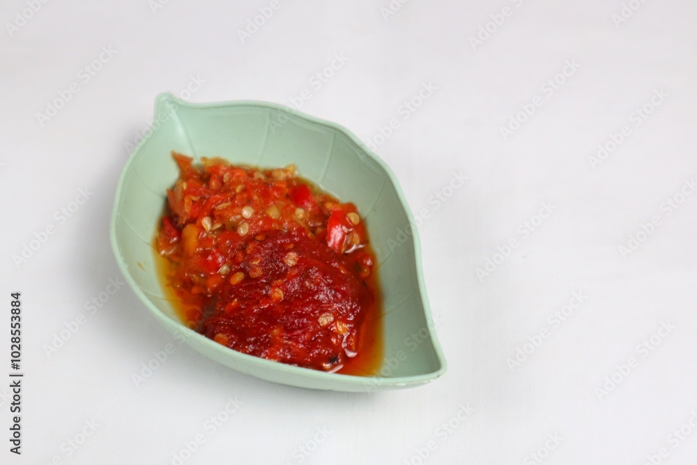 Traditional Indonesian chili sauce namely crushed chilies with shrimp paste, garlic, shallots and spices served in a bowl isolated on a white background Traditional Indonesian chili sauce namely crushed chilies with shrimp paste, garlic, shallots and spices served in a bowl isolated on a white background