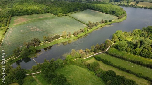 Aerial view of a lush green landscape with fields and a river.