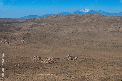 Expansive desert landscape with mountain ranges in the background.