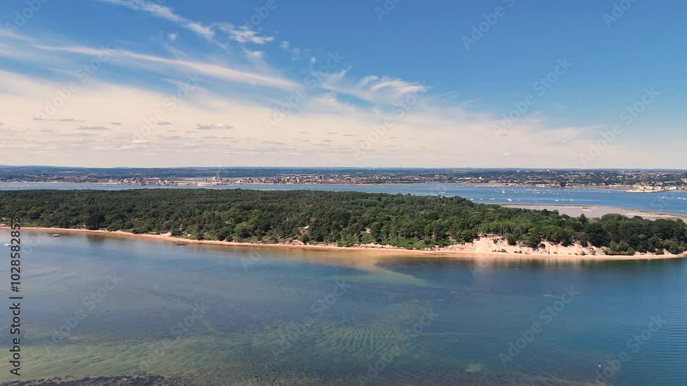 Poole Harbour,drone flight over Brownsea Island with calm clear water,golden sand and magnificent views over this National Trust Property with Poole in the distance on sunny day Poole Harbour,drone flight over Brownsea Island with calm clear water,golden sand and magnificent views over this National Trust Property with Poole in the distance on sunny day