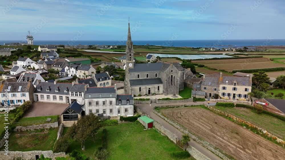 Notre Dame de Bon Secours church surrounded by coastal houses, fields and the sea in the background Notre Dame de Bon Secours church surrounded by coastal houses, fields and the sea in the background