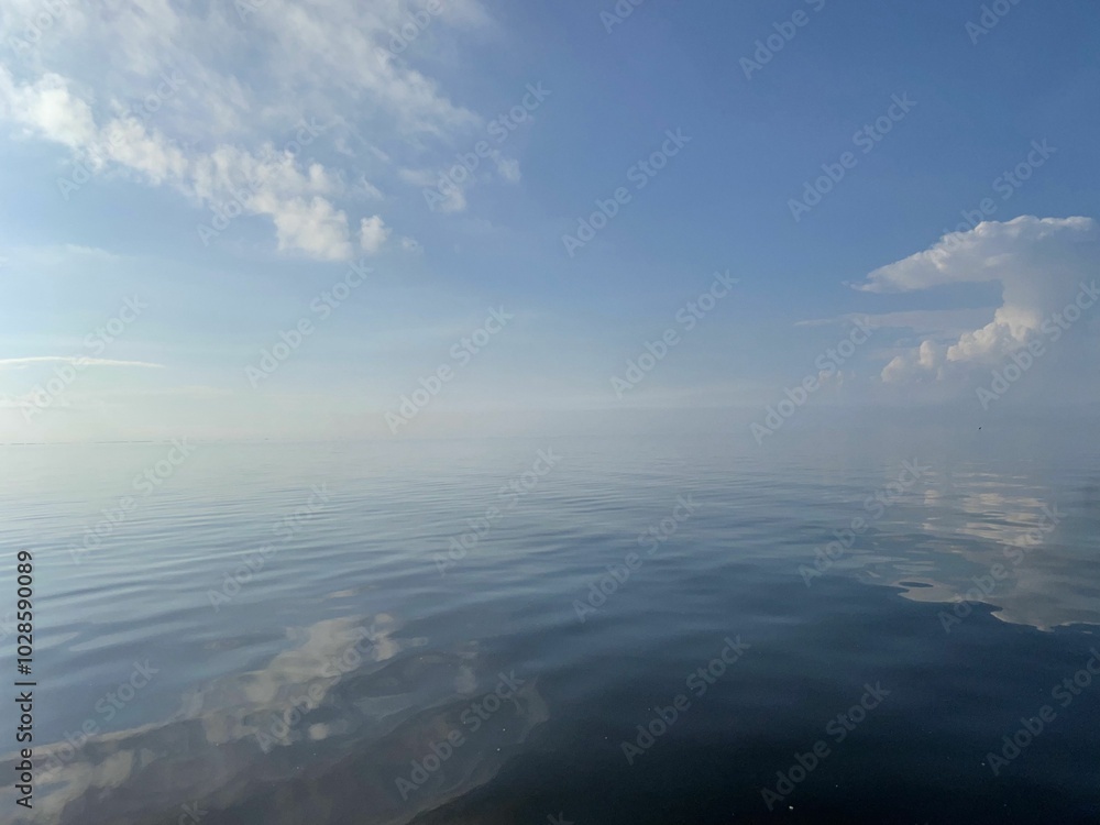 Serene ocean view with clear blue sky and clouds. Serene ocean view with clear blue sky and clouds.