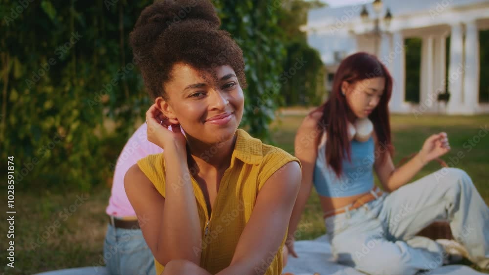 Positive female smiling to camera on background of friends Positive female smiling to camera on background of friends