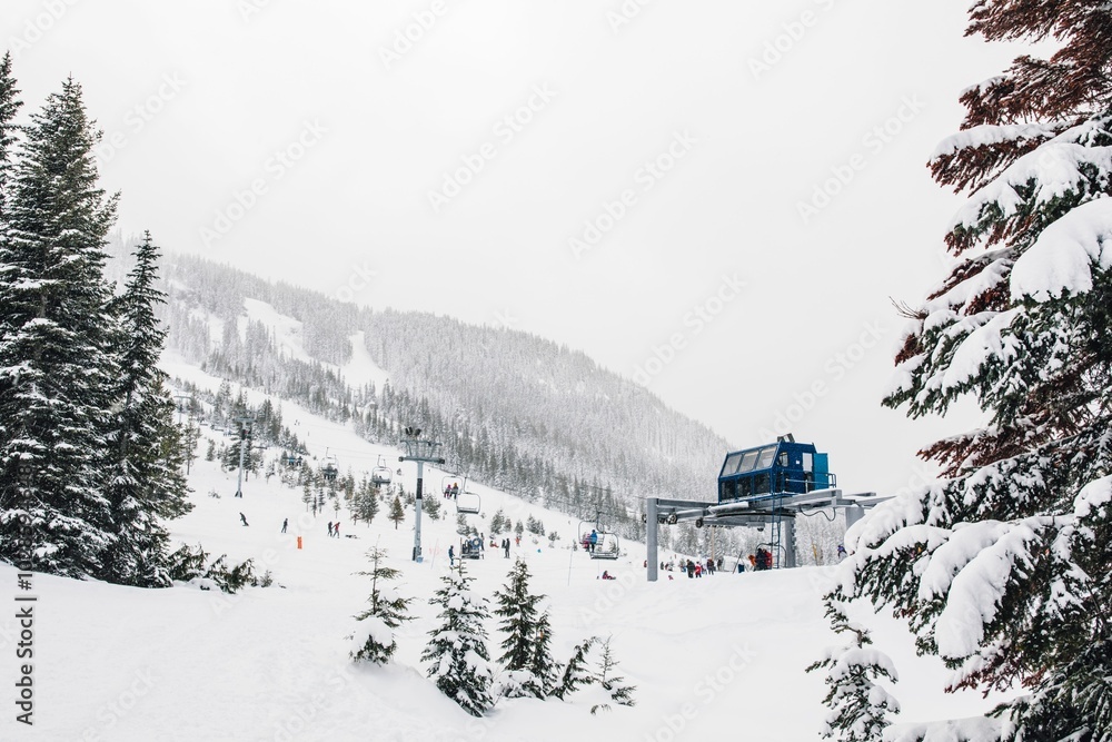 Blue ski lift with skiers in Cascade Mountains Blue ski lift with skiers in Cascade Mountains