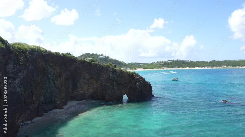 Aerial view of steep cliffs on Baie Rouge beach with blue waters in Saint Martin Island Aerial view of steep cliffs on Baie Rouge beach with blue waters in Saint Martin Island