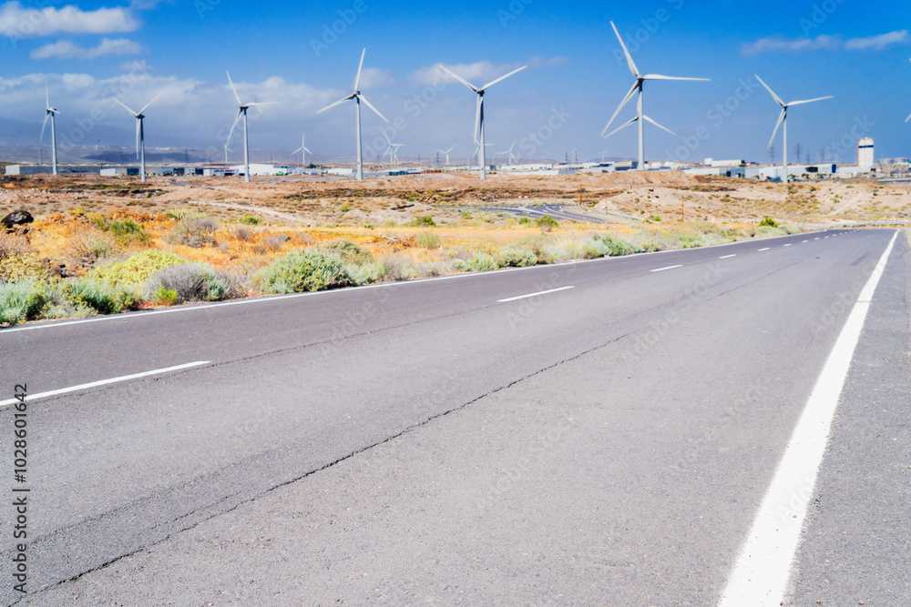 Wind energy concept - road leading to the wind turbines farm Wind energy concept - road leading to the wind turbines farm
