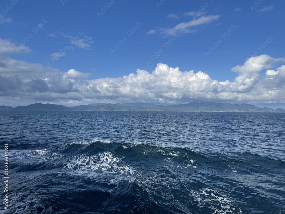 Serene seascape with gentle waves and a distant coastline under a partly cloudy sky from Maizuru, JP Serene seascape with gentle waves and a distant coastline under a partly cloudy sky from Maizuru, JP