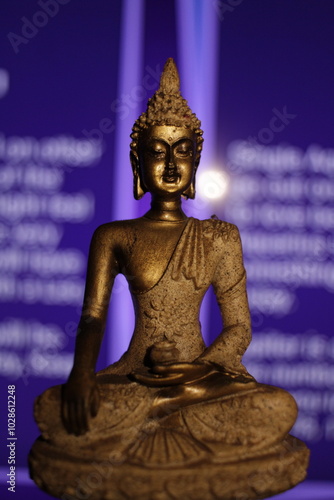 Earth Touching Buddha Statue with colorful backdrop with copy space, Bhumisparsha Buddha, Buddha in a seated meditation pose with his right hand touching the earth. 