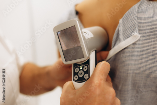 control of moles on the breast by a doctor wearing blue gloves on a female patient palpating the mole